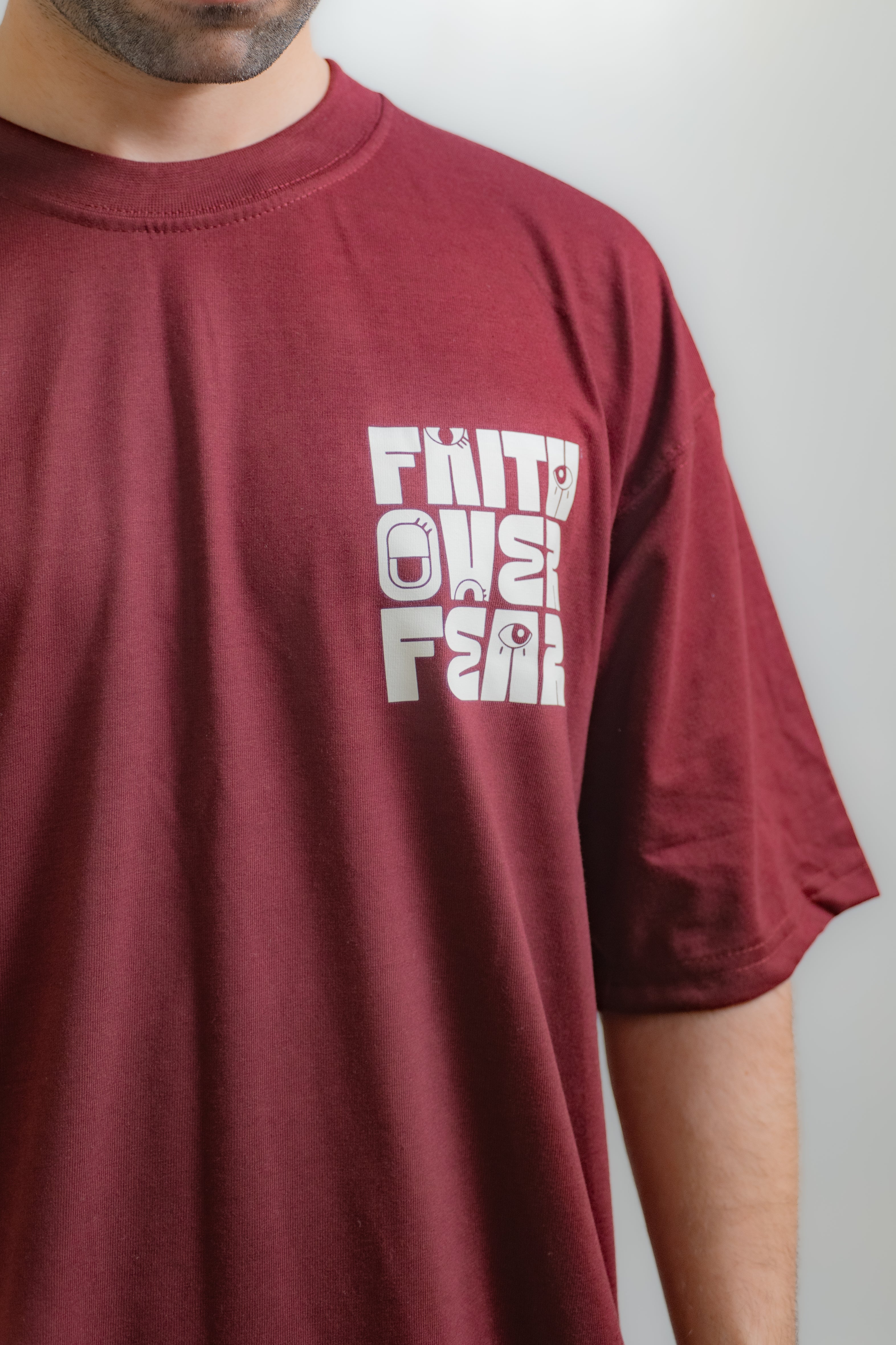 Maroon t-shirt with white text worn by a person against a plain background