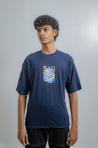 Person wearing a navy blue t-shirt with a colorful graphic design on a plain background