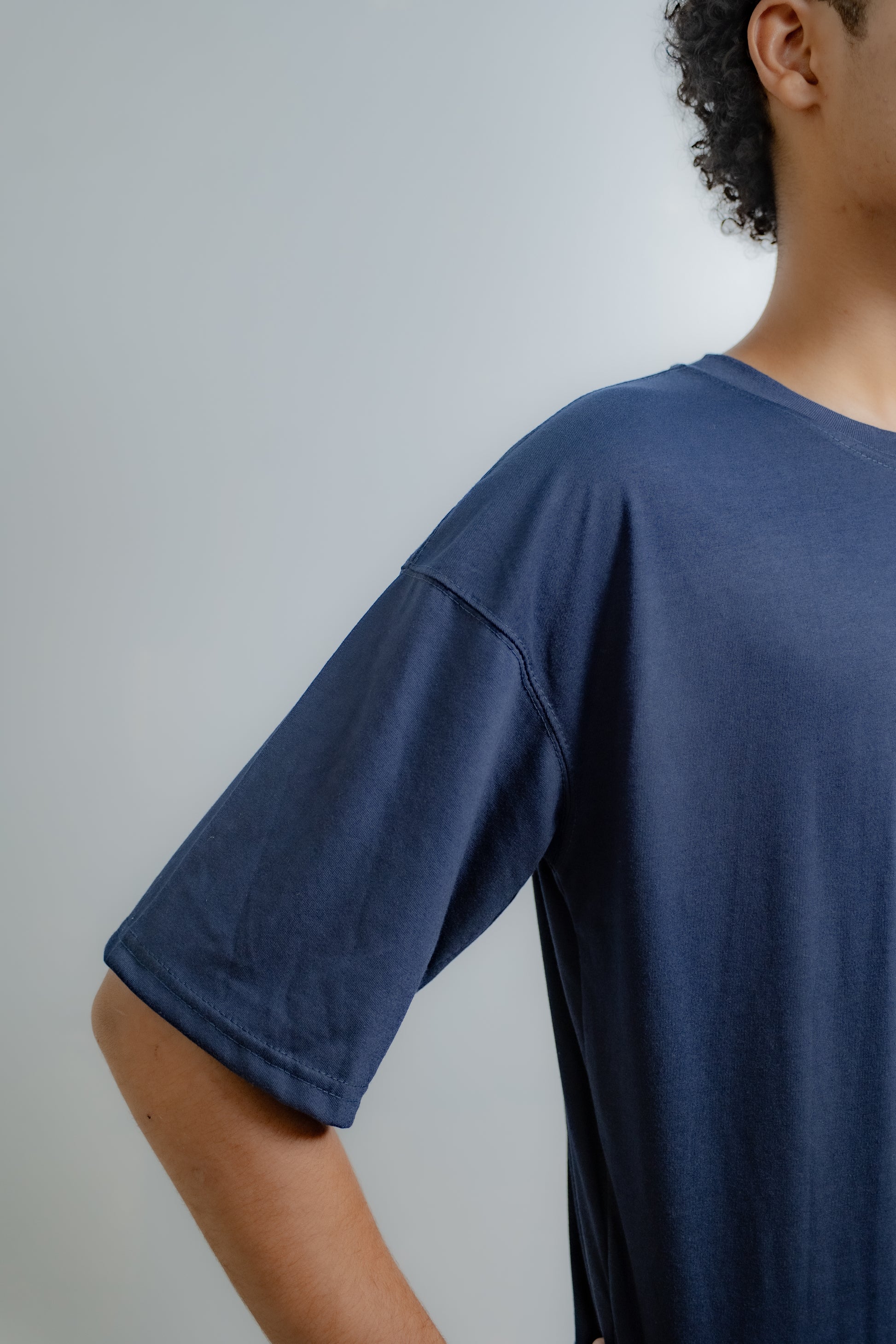 Person wearing a blue t-shirt against a plain background