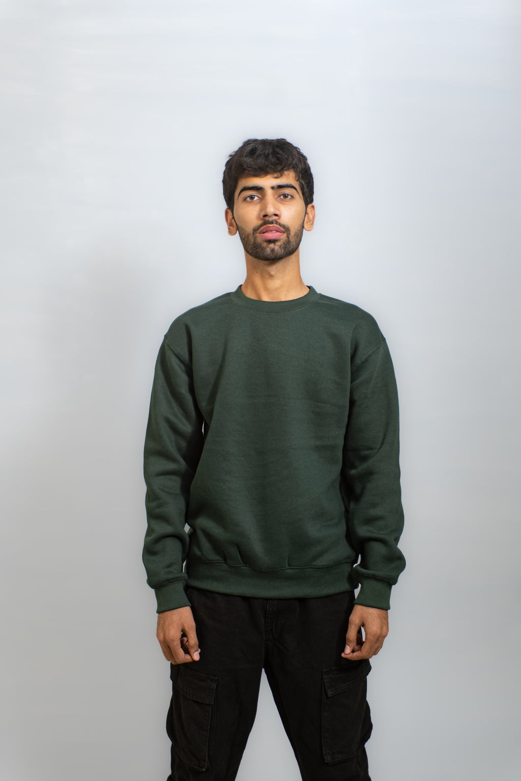 Man wearing a green sweatshirt against a plain background