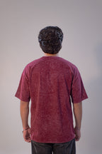 Person wearing a maroon t-shirt against a plain background