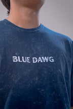 Person wearing a blue t-shirt with 'BLUE DAWG' text on a plain background